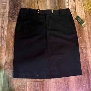 Woman’s mid length black skirt with gold button detail